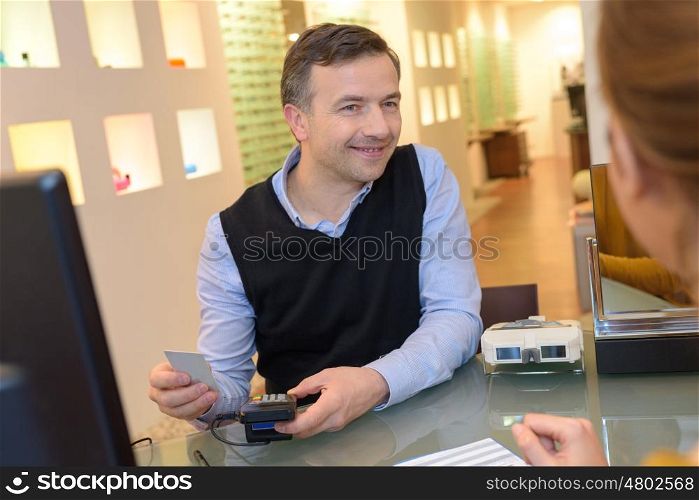 optician issuing credit card to a customer