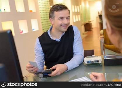 optician issuing credit card to a customer