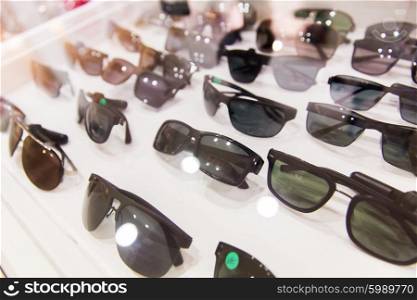optics, accessory and fashion concept - close up of sunglasses at optician