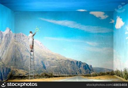 Optimistic approach. Businesswoman standing on ladder drawing sun on wall