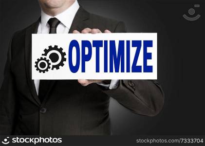 optimize sign is held by businessman background.. optimize sign is held by businessman background