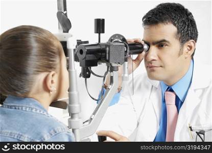 Optometrist examining a girl&acute;s eye
