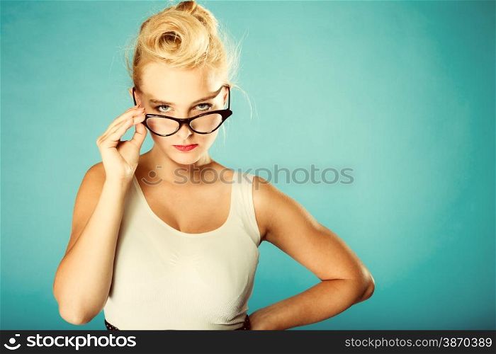 Optometrist, oculist and ophthalmologist concept. Young blonde retro pin up angry woman with eyeglasses in studio. Retro and vintage photo.