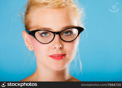 Optometrist, oculist and ophthalmologist concept. Young blonde woman with eyeglasses on blue background in studio.