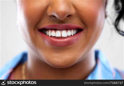 oral care, dental hygiene and people concept - close up of african american woman face with smile and white teeth. close up of african american woman white teeth