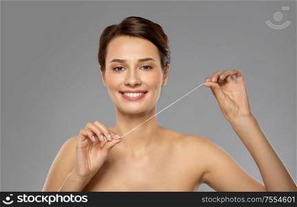oral hygiene, dental care and health concept - happy young woman with floss cleaning teeth. happy young woman with dental floss cleaning teeth