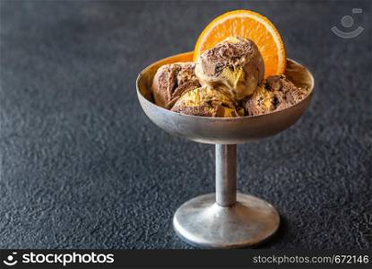 Orange and chocolate ice cream decorated with fresh orange slice in vintage vase