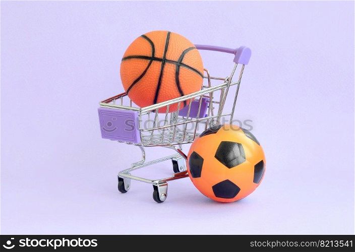 Orange basketball and soccer ball in shopping cart on violet. The concept of selling sports equipment, predictions for sports matches, sports betting. Selling sports equipment. predictions for matches. sports betting