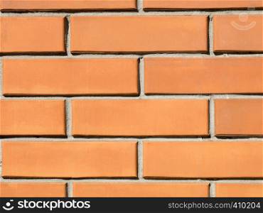 Orange brick wall background close-up on the sunny side. Orange brick wall background.
