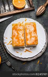 Orange cake with fruit icing on rustic kitchen table, top view