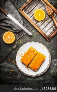 Orange cakes with orange topping on rustic table with fresh orange peel, top view