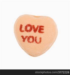 Orange candy heart that reads love you against white background.