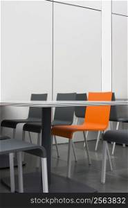 Orange chair amongst grey chairs