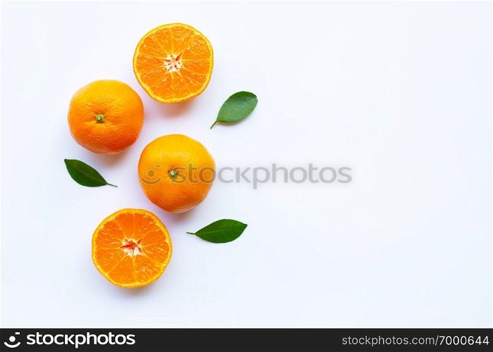 Orange citrus fruit with green leaves on white background.
