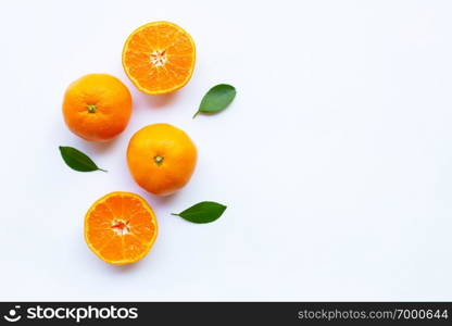 Orange citrus fruit with green leaves on white background.