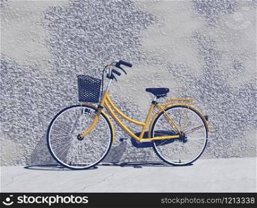 Orange city bike with bascket against a wall in the street y sunny day