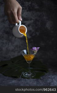 orange cocktail pouring in glass