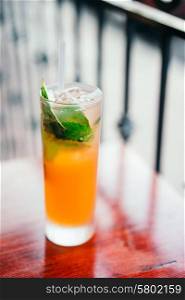 Orange cocktail with mint leaves outdoors