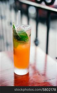Orange cocktail with mint leaves outdoors