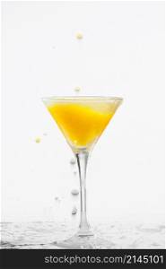 Orange cocktail with splashes on a white background. Orange cocktail