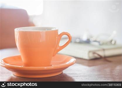 Orange coffee cup with notebook, pen and eyeglasses, stock photo