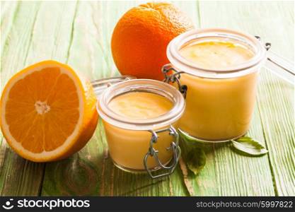 Orange curd in glass jars on the table. The Orange curd