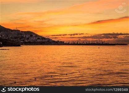 Orange dawn and sunrise over Sitges port, Spain