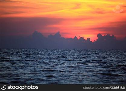 Orange drama sunset over dark gloomy sea