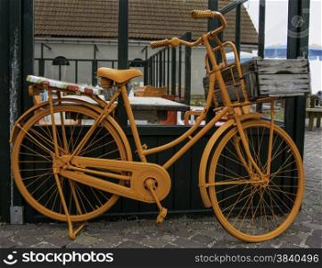 orange dutch bicycle leaning onto a wall