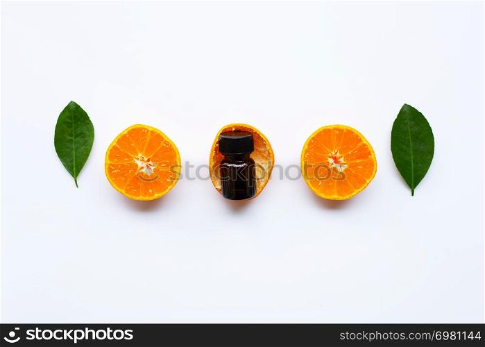 Orange essential oil with fresh orange citrus fruits and green leaves on white background.