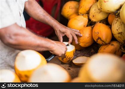 Orange fresh coconut peeling and shelling with heavy chop knife for juice in Male,Maldives