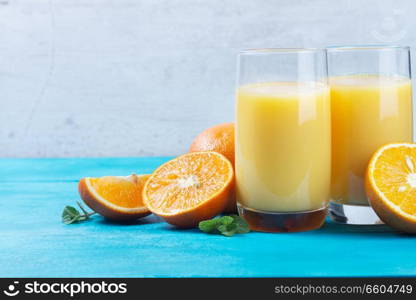 Orange fresh juice - two glasses on blue wooden table. Orange juice in glass