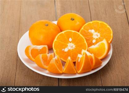 orange fruit in ceramic plate on wood background