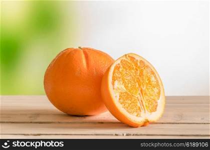 Orange fruit on a wooden outdoor table with green background