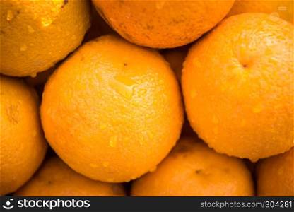 Orange fruit with drops of water.Fresh and wet oranges oranges in the market.. Fresh and wet oranges oranges are for sale.