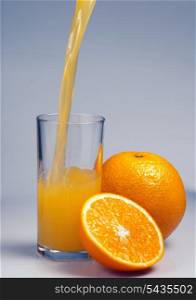 Orange fruit with half part and juice on blue background