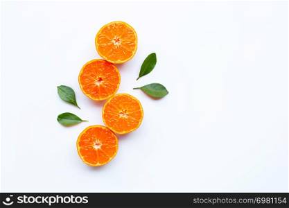 Orange fruits and green leaves on a white background. Copy space