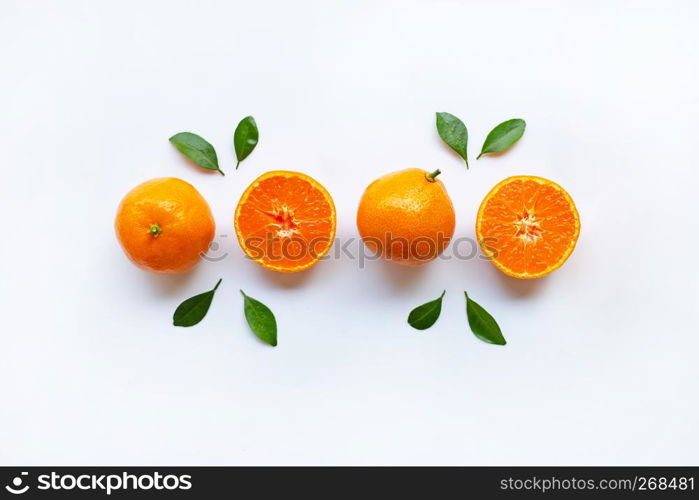 Orange fruits and green leaves on a white background. Top view