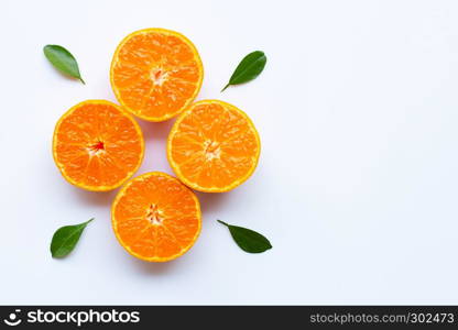 Orange fruits and green leaves on a white background. Top view