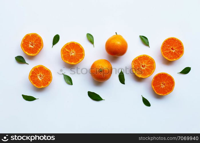 Orange fruits and green leaves on a white background. Top view