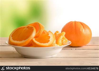 Orange fruits in a white bowl on a wooden table