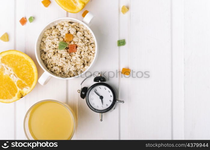 orange glasses oatmeal porridge with alarm clock white table