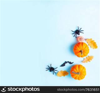 Orange halloween pumpkins on blue background flat lay scene with copy space. Halloween flat lay background