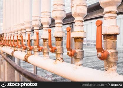 Orange handles on white pipes at a factory