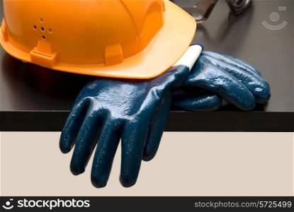 Orange hardhat and leather gloves on table