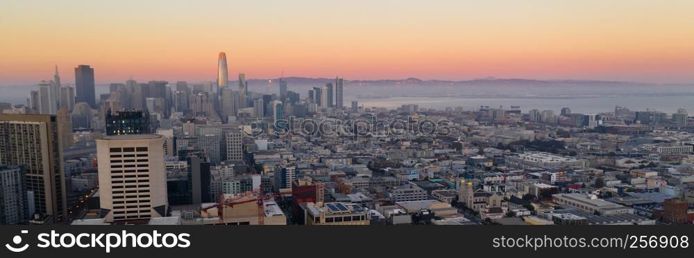 Orange hues seem to bounce off the tallest building as night comes to the San Francisco Bay area