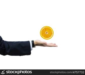Orange in hand. Businessman hand holding juicy orange in palm
