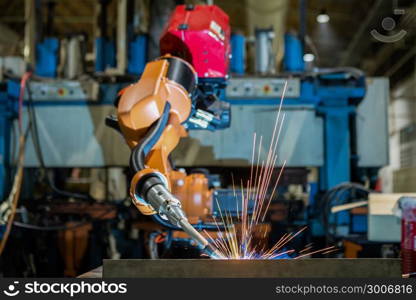 Orange industrial robot is welding assemblycar part in factory