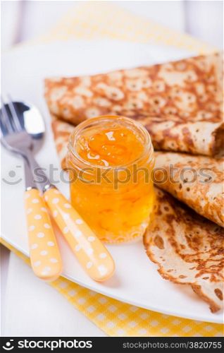 Orange jam with crepes, close up, selective focus