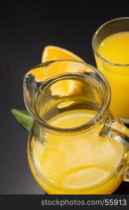 orange juice and fruit on black background